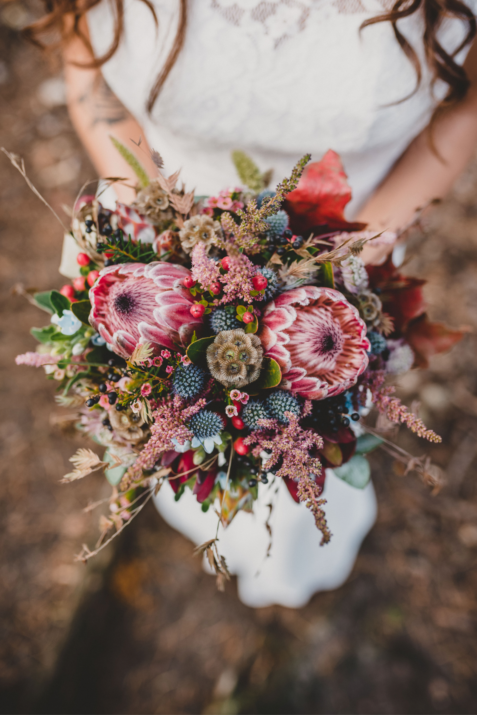 woman holding protea bouquet